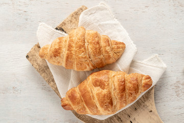 Crispy and delicious croissants on a wooden table