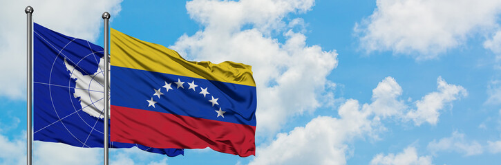 Antarctica and Venezuela flag waving in the wind against white cloudy blue sky together. Diplomacy concept, international relations.