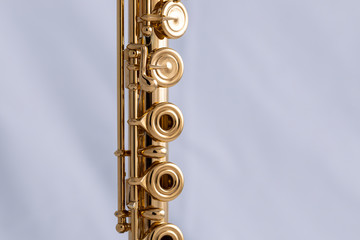 A gold plated flute on a white background. An instrument common in the symphony orchestra