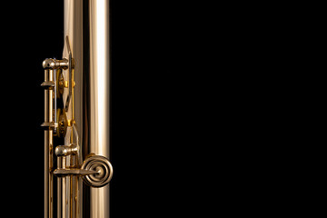 A part of a gold plated flute on a black background. An instrument common in the symphony orchestra