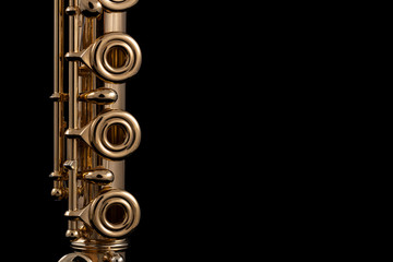 A part of a gold plated flute on a black background. An instrument common in the symphony orchestra