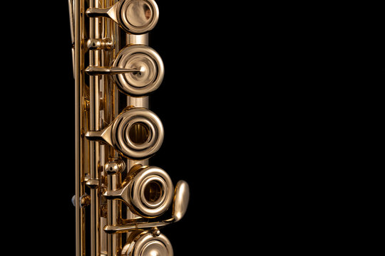 A part of a gold plated flute on a black background. An instrument common in the symphony orchestra