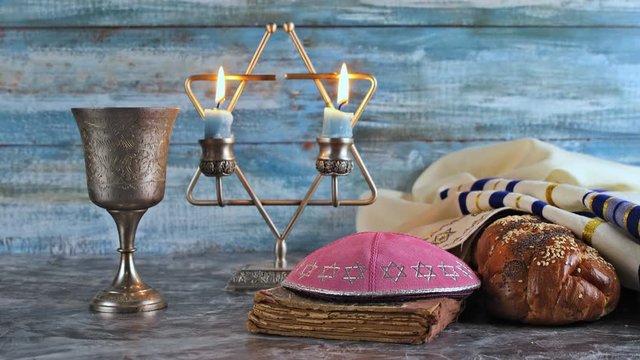 Shabbat Jewish holiday with challah bread on a candles and cup of wine.