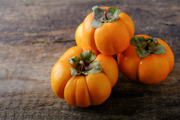 Ripe, juicy persimmon on a wooden table.