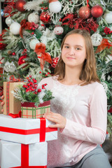 Girl with gifts on the background of the Christmas tree.