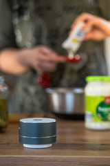 Smart ai speaker with woman cooking in the background. Smart home concept