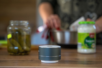 Smart ai speaker with woman cooking in the background. Smart home concept