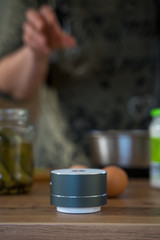 Smart ai speaker with woman cooking in the background. Smart home concept