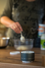 Smart ai speaker with woman cooking in the background. Smart home concept
