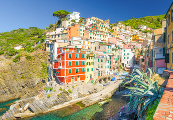 Riomaggiore traditional typical Italian fishing village in National park Cinque Terre, colorful multicolored buildings houses on hill, clear blue sky copy space background, La Spezia, Liguria, Italy