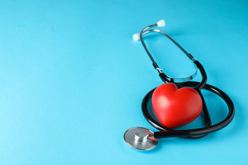 Stethoscope and heart on blue background, space for text. Healthcare