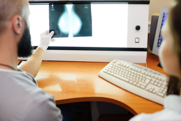 the doctor and the patient are watching a mammogram-the result of x-ray examination of the mammary glands for the prevention of breast cancer