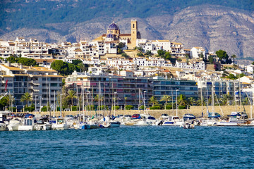 ALTEA, SPAIN - OCTOBER 14, 2019: Port of Altea with elegant yachts and view to the old town with its cathedral