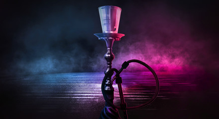 Hookah on a dark background, neon light. Abstract blue and pink neon light smoke background.