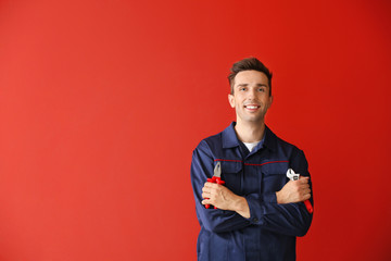 Male car mechanic on color background