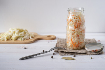 Pickled cabbage with carrot in glass jar. Homemade preserving. Russian traditional preserving food.