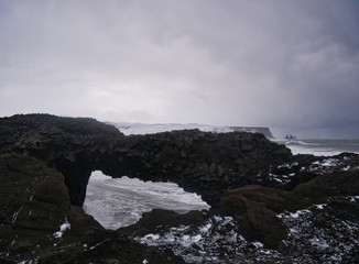 Fototapeta na wymiar Blick durch ein Felsloch auf die Küste von Island