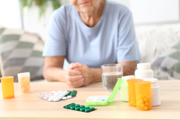 Elderly woman with medicines at home