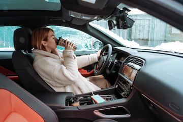 Attractive woman driver nsitting behind the steering wheel in her car