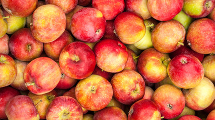 Ripe red apples lie on the counter of the village market