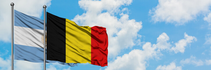 Argentina and Belgium flag waving in the wind against white cloudy blue sky together. Diplomacy concept, international relations.