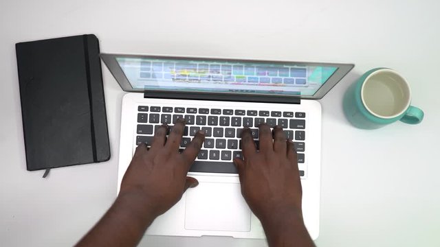 Keeping laptop on wooden table and typing with hands 