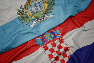 waving colorful flag of croatia and national flag of san marino.