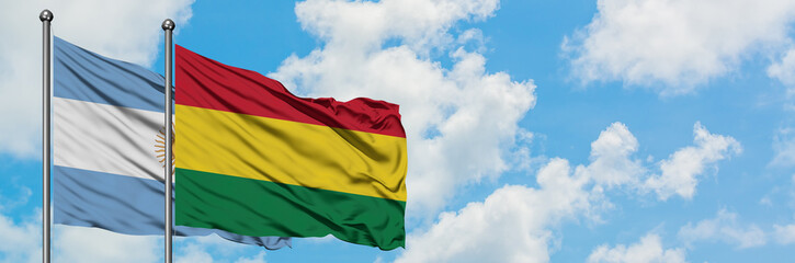 Argentina and Bolivia flag waving in the wind against white cloudy blue sky together. Diplomacy concept, international relations.