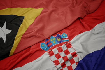 waving colorful flag of croatia and national flag of east timor.