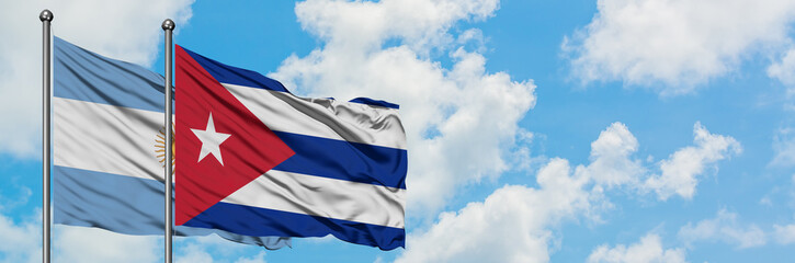 Argentina and Cuba flag waving in the wind against white cloudy blue sky together. Diplomacy concept, international relations.