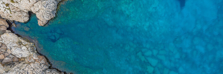 An aerial view of the beautiful Mediterranean sea, where you can se the rocky textured underwater corals and the clean turquoise water of blue lagoon Agia Napa