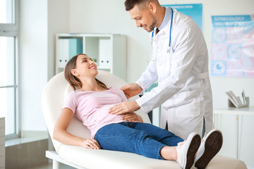 Male gynecologist working with pregnant woman in clinic