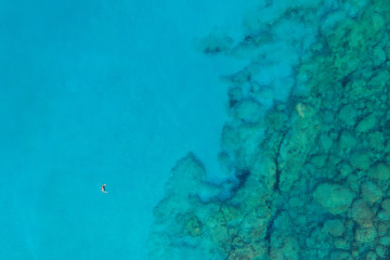 An aerial view of the beautiful Mediterranean sea, where you can se the rocky textured underwater corals and the clean turquoise water of blue lagoon Agia Napa