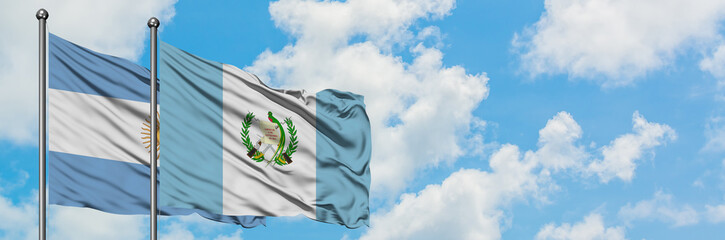 Argentina and Guatemala flag waving in the wind against white cloudy blue sky together. Diplomacy...