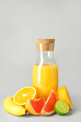Bottle of fresh fruit juice on grey background