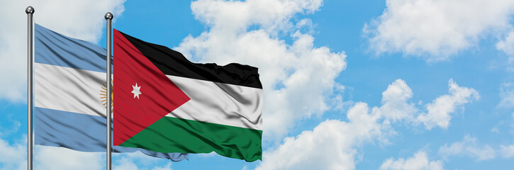 Argentina and Jordan flag waving in the wind against white cloudy blue sky together. Diplomacy concept, international relations.