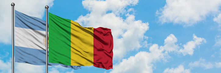 Fototapeta premium Argentina and Mali flag waving in the wind against white cloudy blue sky together. Diplomacy concept, international relations.