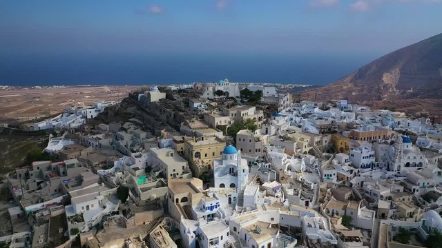 Aerial drone video of iconic small traditional village and uphill castle of Pyrgos with great views to Santorini island Cladera, Cyclades, Greece