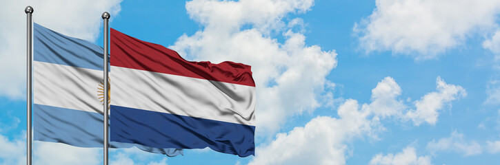 Argentina and Netherlands flag waving in the wind against white cloudy blue sky together. Diplomacy concept, international relations.