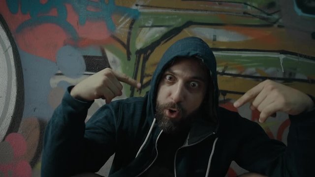 An eccentric controversial energetic  male urban rapper.Portrait and various performance shots of him performing in an underground city passage.