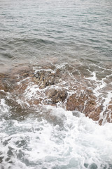 mar y una ola chocando contra las rocas