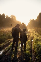  father pointing and guiding son on first deer hunt © romankosolapov