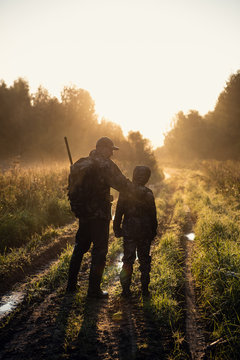 father pointing and guiding son on first deer hunt