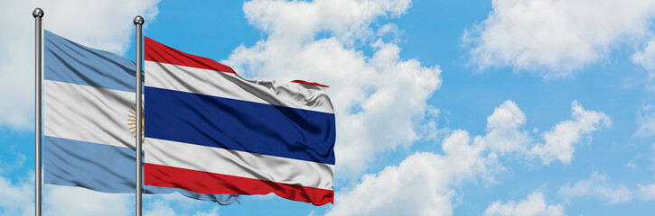 Argentina and Thailand flag waving in the wind against white cloudy blue sky together. Diplomacy concept, international relations.