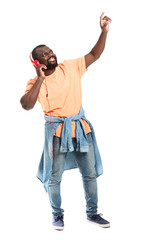 Handsome African-American man listening to music on white background