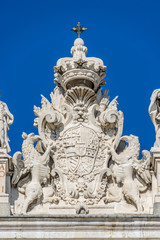 Fototapeta na wymiar Madrid Royal Palace (Palacio Real) Top East facade. Coat of arms of Phillip V, with the collars of the Orders of the Golden Fleece and of the Holy Spirit.