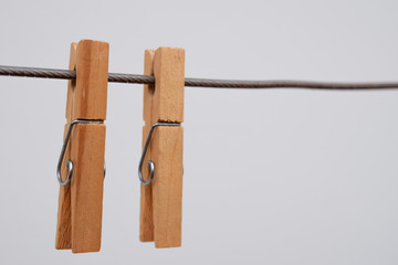 two wooden clothespins hanging on the clothesline