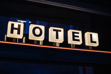 Hotel sign text on the illuminated square white lamps in central part of the city in modern megapolis