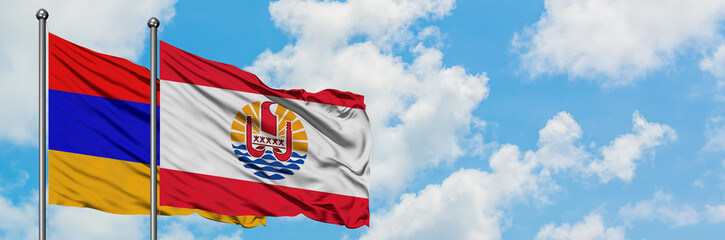 Armenia and French Polynesia flag waving in the wind against white cloudy blue sky together. Diplomacy concept, international relations.