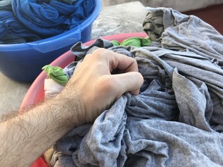 Basket full of clean laundry with a hand picking some clothes